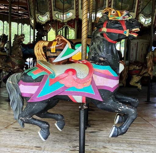 A carousel with horses on it

AI-generated content may be incorrect.