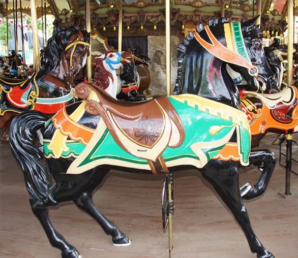 A group of horses on a merry go round

Description automatically generated
