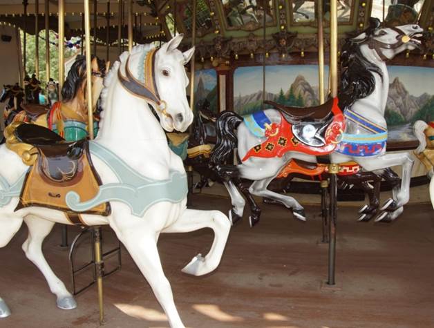 A group of horses on a merry go round

Description automatically generated