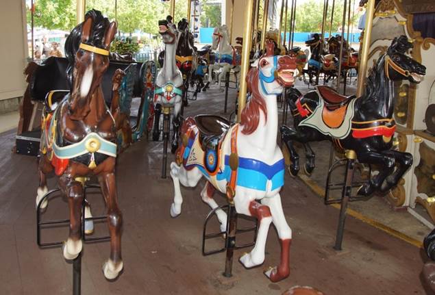 A group of horses on a merry go round

Description automatically generated