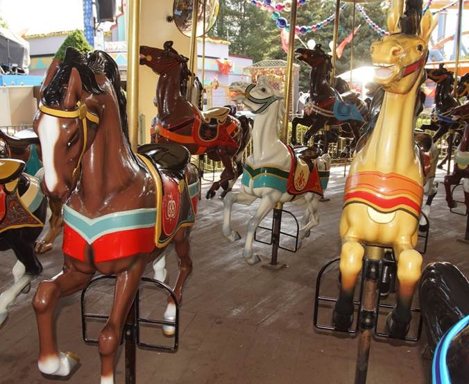 A group of horses on a merry go round

Description automatically generated