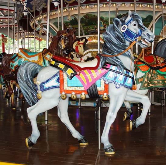 A carousel with horses on a wooden floor

Description automatically generated