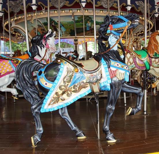 A carousel with horses on a wooden floor

Description automatically generated