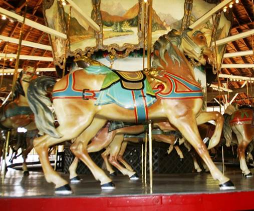 A carousel with horses on a red platform

Description automatically generated